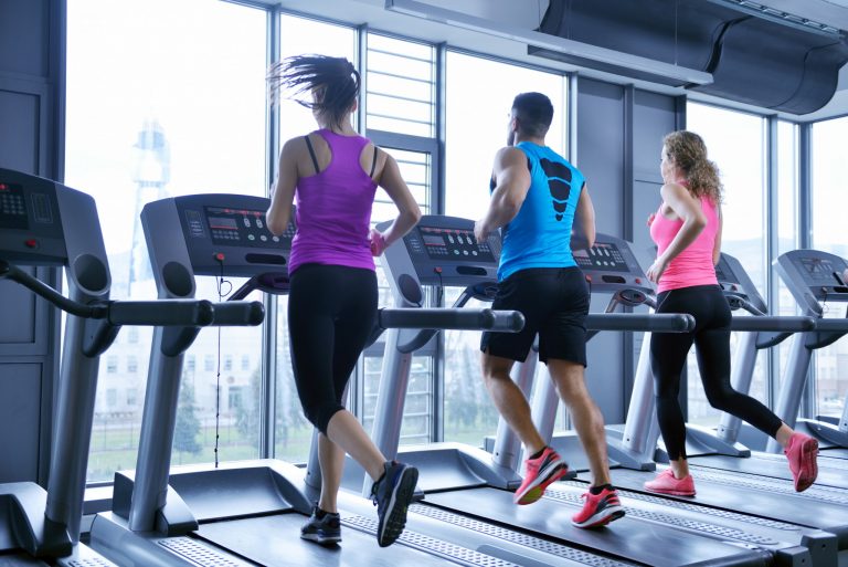 Group of people running on treadmills